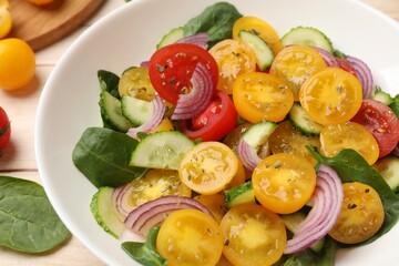 Fresh salad with yellow tomatoes on table, closeup
