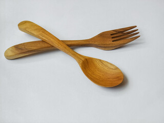 spoon and fork made of wood on a white background