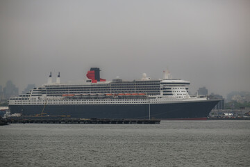 Luxury ocean liner cruiseship cruise ship Queen Mary docked at terminal in Brooklyn on grey rainy...