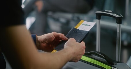 International Airport Terminal: Close Up of Passenger with Luggage Sitting in Departure Lounge of Airline Hub, Holding Passport with Boarding Pass. Traveler Waiting for Flight, Going on Holiday Trip.