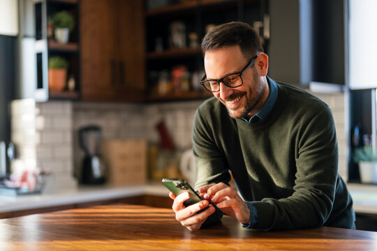 Success business man holding cell phone using smartphone watching video or having mobile chat call.