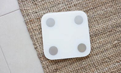 White blank digital scale on floor at home. Weight loss concept