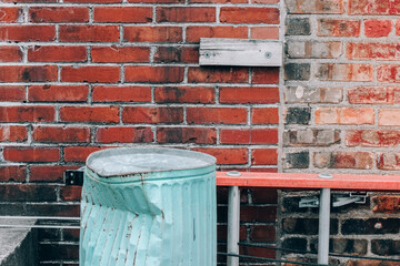 red brick wall with trash can