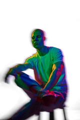 Portrait of attractive and serious bald young man in white t-shirt posing against white background...