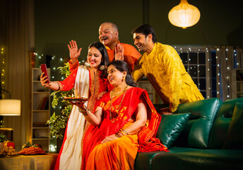 Fototapeta premium Smiling Indian family celebrating Diwali indoors with decorations enjoying festival moments together