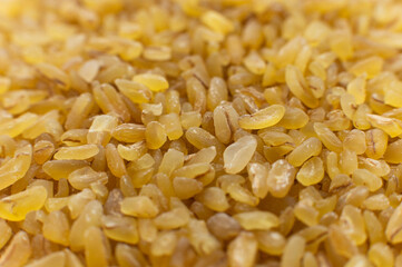 Cereal grains of bulgur. Macro shot. Closeup view of cracked wheat. Healthy eco food. Product of organic farming