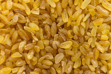 Cereal grains of bulgur. Macro shot. Closeup view of cracked wheat. Healthy eco food. Product of organic farming
