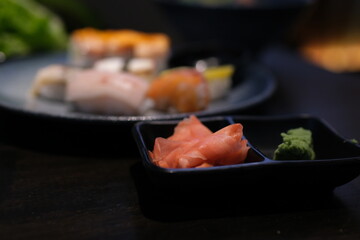 Sushi rolls set with marinated ginger, soy sauce and wasabi on stone background, selective focus. High quality photo