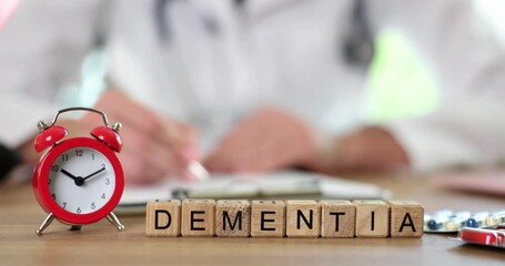 Doctor writes prescription for Dementia on cubes treatment by alarm clock and pills on desk in clinic. Importance of timely diagnosis and intervention