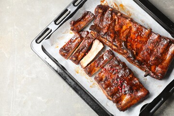 Delicious spare ribs on grey textured table, top view. Space for text
