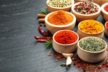 Different aromatic spices on black table, closeup. Space for text