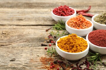 Different aromatic spices on wooden table, closeup. Space for text