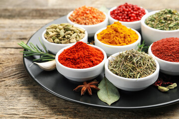 Different aromatic spices on wooden table, closeup