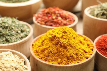 Different aromatic spices in bowls on table, closeup