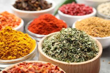 Different aromatic spices in bowls on table, closeup