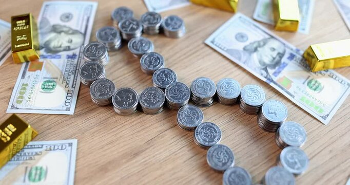 Armenian dram coins create dollar sign on wooden table surrounded by dollar bills and gold bars. Financial transactions and investment strategies