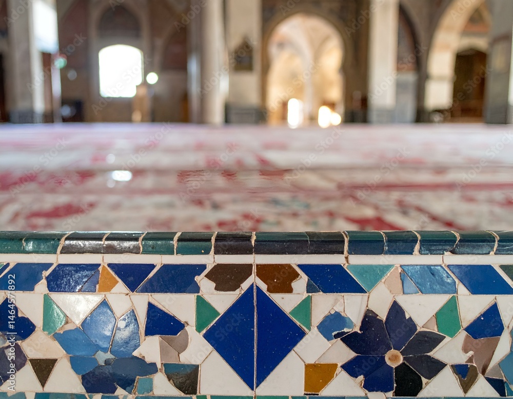 Poster close-up of intricately patterned mosaic tilework in a grand hall, blurred background showing arches