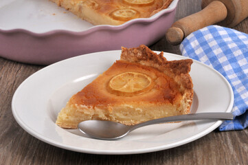 Part de tarte au citron faite maison dans une assiette avec une cuillère en gros plan