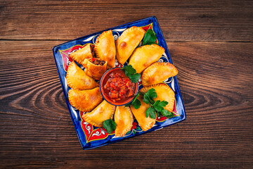 artisan argentinian homemade empanadas with minced meat and salsa dip