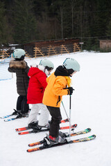 Excitement fills the air as young skiers take on the snowy slopes at a ski resort surrounded by...