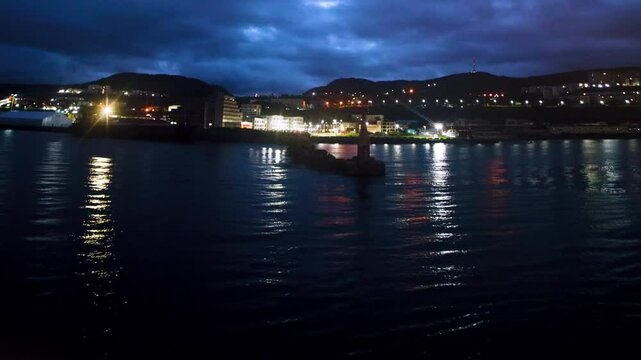 The seaport and port city of Vanino on the Sea of Japan, Khabarovsk Territory. Evening view panorama of houses on the mountainside along the pier. Nightscape