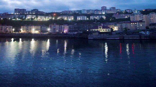The seaport and port city of Vanino on the Sea of Japan, Khabarovsk Territory. Evening view panorama of houses on the mountainside along the pier. Nightscape