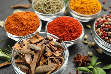 Different aromatic spices on grey table, closeup