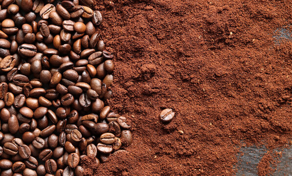 Coffee beans and ground coffee background. Roasted coffee beans on dark wooden background. Invigorating drink. Copy space. Top view of beans and coffee powder