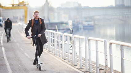 Young businessman on e scooter in the city