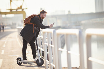 Young businessman on e scooter in the city