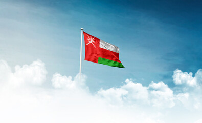 Oman national flag with mast waving in beautiful sky. Oman flag for Republic Day and Independence Day.