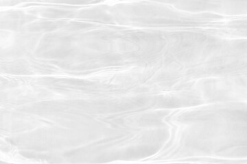 White water with ripples on the surface. Defocus blurred transparent white colored clear calm water surface texture with splashes and bubbles. Water waves with shining pattern texture background.