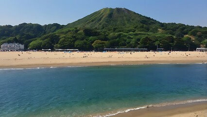 A serene beach scene with a lush mountain backdrop, clear water, and people enjoying the sunny day.