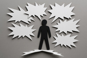 Paper cutout person surrounded by toxic speech bubbles symbolizing negative communication stress and emotional impact in conceptual style