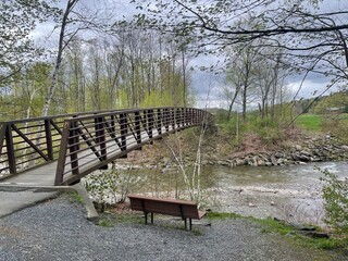 A walking bridge crosses a river in the Vermont countryside
