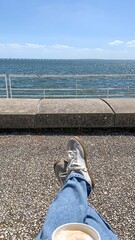 Seaside serenity with sneakers and latte under sunlit whispers, celebrating Leisure Day and Coastal...
