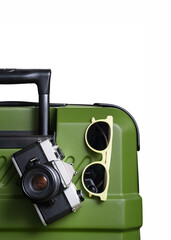Vertical images a green suitcase with a camera and sunglasses on top of it. isolated white background