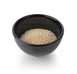 White sesame seeds in black ceramic bowl on white background