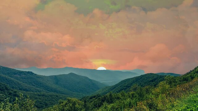 A video animation depicting a morning landscape with intricate mountains in the foreground. Behind them, the sun is rising, casting the light of dawn. Clouds are drifting along with the breeze.