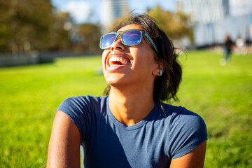 Close up portrait laughing woman wearing sunglasses in the park
