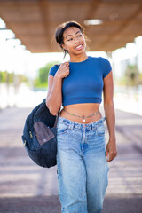 portrait young woman walking with bag outdoors