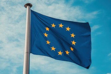 European union flag waving against a bright blue sky with soft white clouds