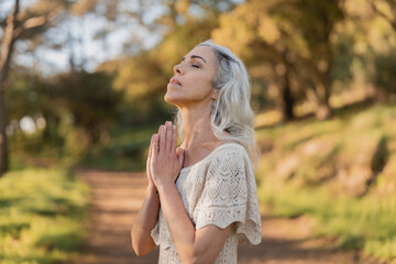 An older woman engages in mindful meditation, embracing tranquility in a serene outdoor...