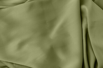 Elegant fabric texture in green color with soft flowing folds and creases