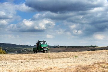 Small three-wheeler on the Sienese hills among the fields after the harvest