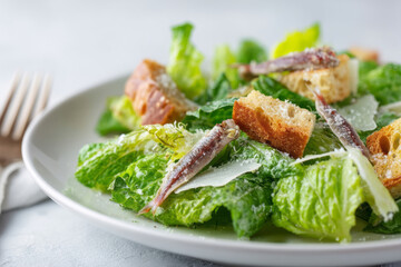 Crisp romaine caesar salad with salty anchovies and crunchy croutons evokes Mediterranean feasts and unconventional Salad Day celebrations