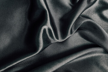 Elegant dark fabric draped softly on a smooth surface for textile design and inspiration