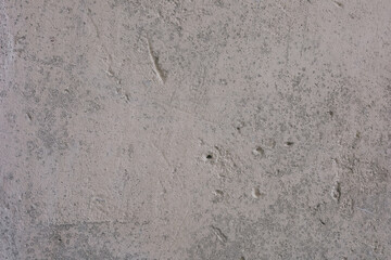 Untreated concrete wall texture with natural flaws and color variations in daylight