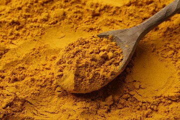 Superfood supplement. Turmeric powder and spoon, closeup