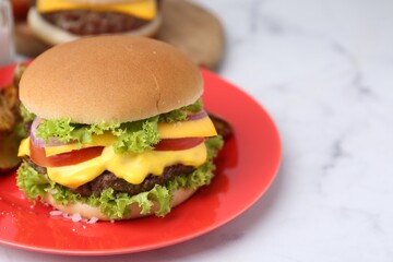 Tasty cheeseburger on white marble table, closeup. Space for text